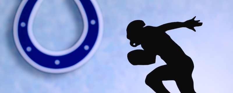 Indianapolis Colts. Silhouette of professional american football player. Logo of NFL club in background, edit space.